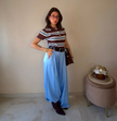 Claure Mode one-size light blue satin wide-leg trousers worn by a woman with a striped top and black belt