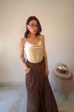 Modella indossa pantaloni Claure Mode color cioccolato gessati a palazzo con cintura regolabile e top in seta
