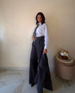 Modella indossa pantalone Claure Mode Back to office wide leg grigio elasticizzato con cintura regolabile