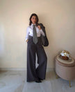 Modella Claure Mode indossa pantalone wide leg grigio elasticizzato con cintura regolabile in stile office