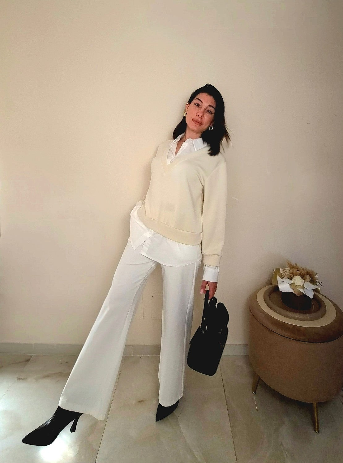 Modella indossa pantaloni Claure Mode Paige bianchi elasticizzati a gamba larga con camicia e maglione
