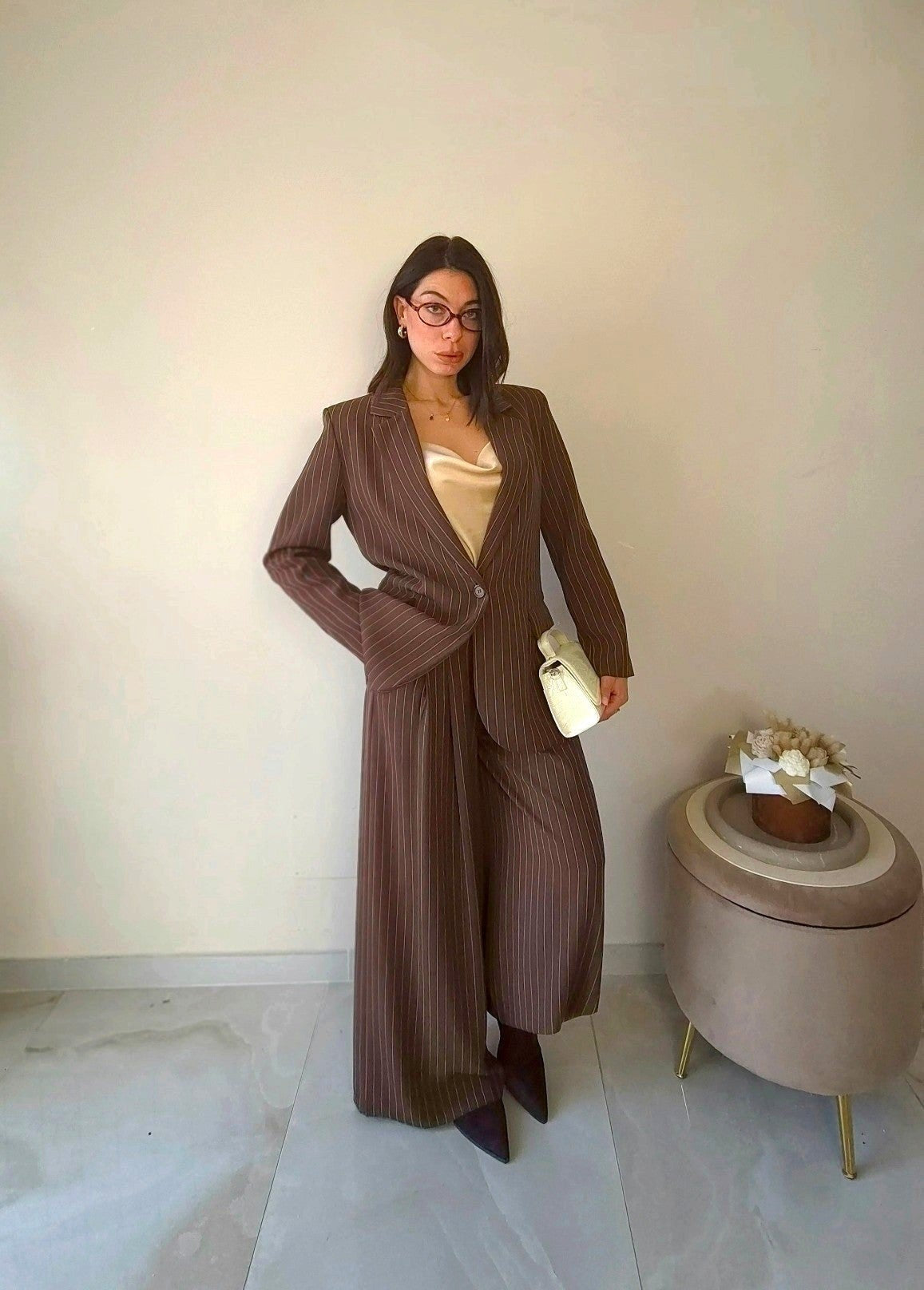 Modella indossa tailleur Claure Mode marrone gessato con giacca monopetto e pantaloni a palazzo color cioccolato