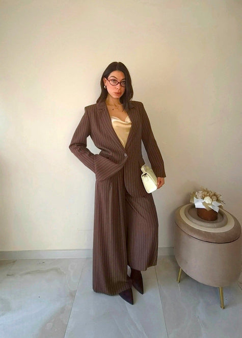 Modella indossa tailleur Claure Mode marrone gessato con giacca monopetto e pantaloni a palazzo color cioccolato